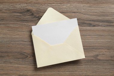 Boş davetiye kartı ve zarf ahşap masa, üst görünüm