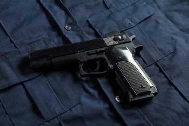 Koyu mavi üniformalı siyah silah, yukarıda. Polis ekipmanı