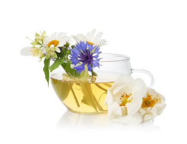 Cam bardakta aromatik bitki çayı ve beyaz bardakta izole edilmiş çiçekler.