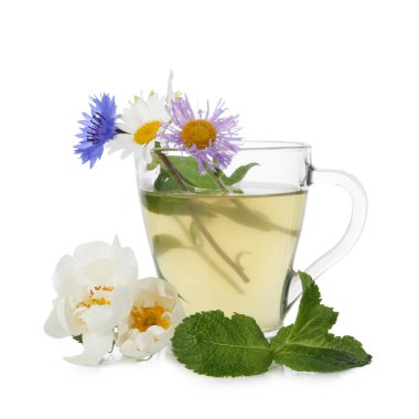 Cam bardakta aromatik bitki çayı, beyaz bardakta izole edilmiş nane ve çiçekler.