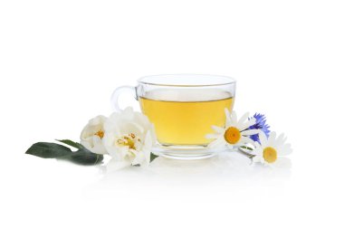 Cam bardakta aromatik bitki çayı ve beyaz bardakta izole edilmiş çiçekler.