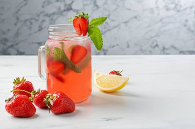 Çilekli içecek ve beyaz masada nane şekeri gri mermer arka planda, yakın plan. Metin için boşluk