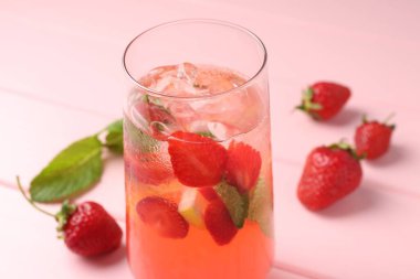 Çilekli içecek, pembe ahşap masadaki nane ve buz, yakın plan.
