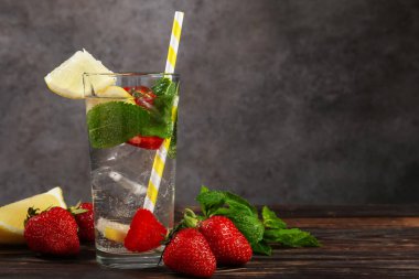 Çilekli, limonlu ve naneli içecek, ahşap masada, gri desenli arka planda. Metin için boşluk