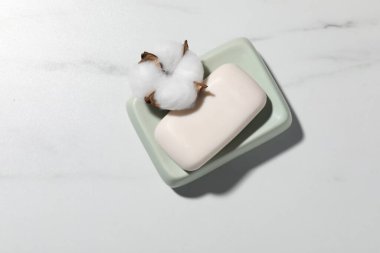 Sabun çubuğu ve pamuk çiçeği beyaz mermer masa, üst manzara