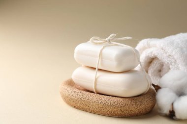 Sabun çubukları, havlu ve bej arka planda pamuk çiçeği, yakın plan. Metin için boşluk