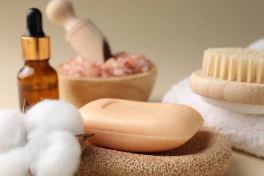 Sabun çubuğu, kozmetik ürünleri ve koyu bej arka planda pamuk çiçekli kompozisyon, yakın plan