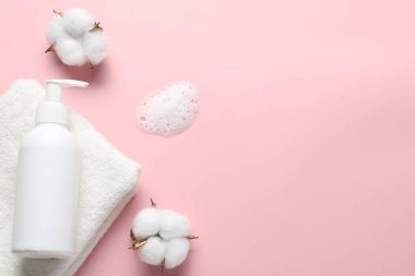 Düz kompozisyon, pembe zemin üzerinde sıvı sabun ve pamuk çiçekleri vardı. Metin için boşluk