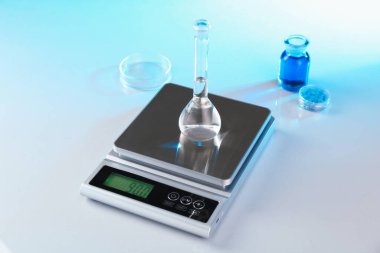 Örnekler ve laboratuvar camlarıyla beyaz masa üzerinde renk ışıklarıyla ölçeklendir, yakın plan