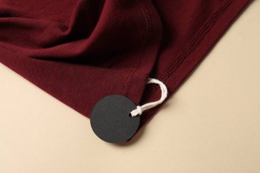 Bej arkaplanda etiketli kırmızı giysi, üst görünüm