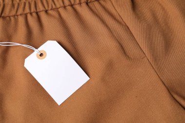 Kahverengi pantolondaki karton etiket, yukarıdan.