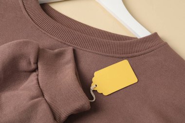 Üzerinde bej arkaplan etiketi olan kahverengi giysi, yukarıda görünüm