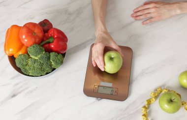 Kadın mutfak terazisinde ağırlıklı beyaz mermer masa, üst manzara