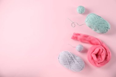 Pembe arka planda yün ve örgü ipliği, düz yatış. Metin için boşluk