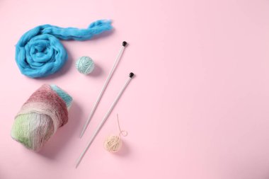 Pembe arka planda iğneli yün ve örgü ipliği, düz yatış. Metin için boşluk