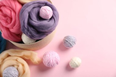 Pembe arka planda yün ve örgü ipliği hissediyorum. Metin için boşluk