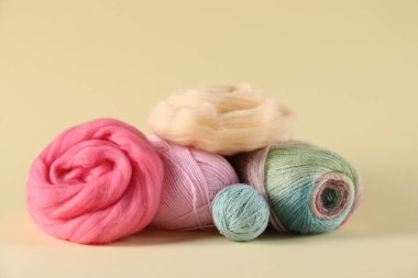 Bej arka planda yün ve örgü ipliği hissetmek, yakın plan