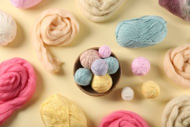 Bej arka planda yün ve örgü ipliği, düz yatış