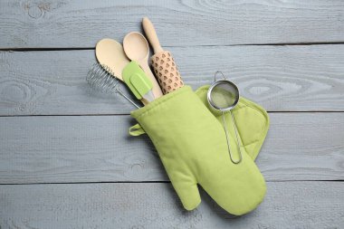 Farklı mutfak gereçleri fırın eldiveni açık gri ahşap masa, üst manzara
