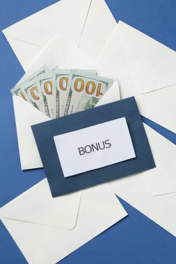 Zarflar kelime bonus ve para mavi arka planda, düz yatıyordu
