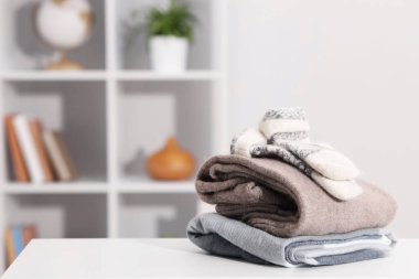 Beyaz masa üzerinde yün giysiler yığını, metin için boşluk