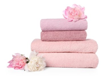 Havlu yığını ve şakayık çiçekleri beyaz üzerine izole edilmiş.