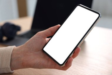 Masadaki modern akıllı telefonu kullanan kadın, yakın plan.