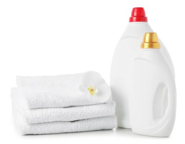 Kumaş yumuşatıcı şişeler, yığılmış havlular ve beyaz üzerine izole edilmiş çiçekler.