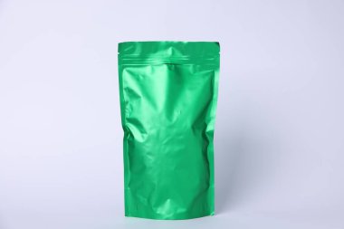 Açık gri arka planda fermuarlı bir stand-up kesesi. Tasarım için model