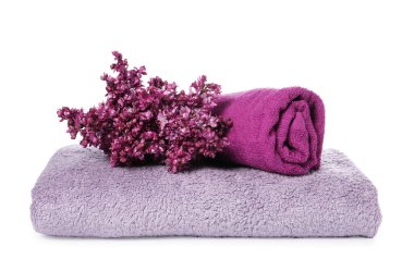 Yumuşak havlular ve beyaza ayrılmış leylak çiçekleri.