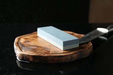 Keskinleştirici ve bıçak siyah ayna yüzeyinde, yakın plan.