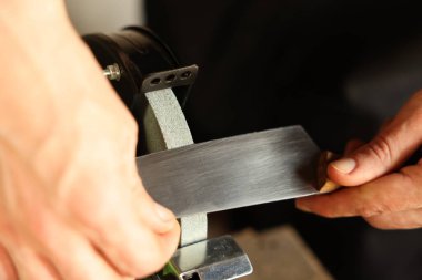 Bıçak keskinleştiren adam içeride, yakın plan.