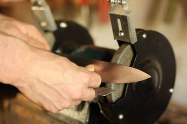 Bıçak keskinleştiren adam içeride, yakın plan.