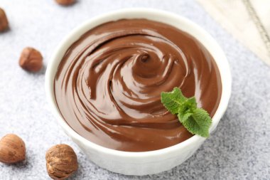 Lezzetli çikolata, naneli kase ve fındıklı gri desenli masa, yakın plan.