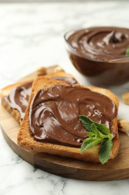 Çikolata, naneli ve fındıklı beyaz mermer masa, yakın plan.