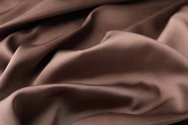 Arkaplan olarak buruşuk açık kahverengi ipek kumaş, yakın plan