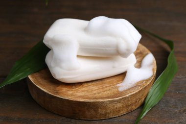 Köpüklü sabun çubukları ahşap masada, yakın plan.