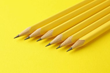 Sarı arkaplanda birçok grafit kalem, yakın plan