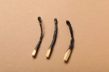 Bej arkaplanda yanmış kibritler, yakın plan görünümü