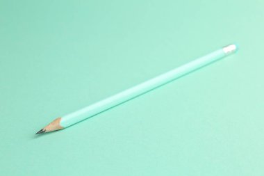 Turkuaz arka planda silgisi olan bir grafit kalem, yakın plan.