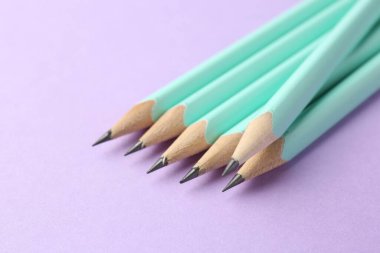 Menekşe arkaplan üzerinde birçok grafit kalem, yakın plan