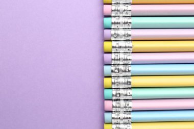 Menekşe arkaplanda silgisi olan bir sürü grafit kalem. Metin için boşluk