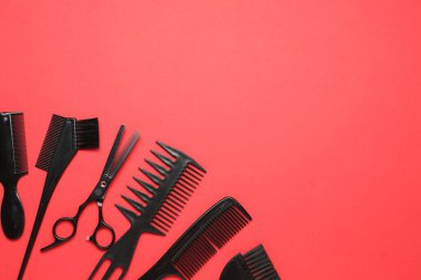 Kırmızı arka planda farklı kuaför aletleri var. Metin için boşluk
