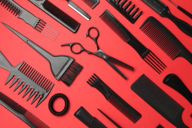 Kırmızı arka planda farklı kuaför aletleri, düz yatıyordu