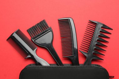 Farklı kuaför aletleri ve kırmızı arka planda çanta, düz yatıyordu