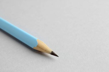 Açık gri arka planda bir grafit kalem, yakın plan. Metin için boşluk