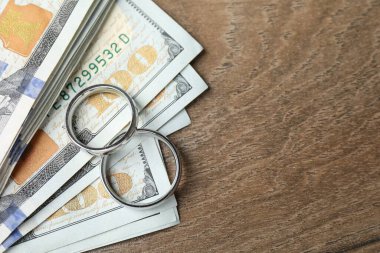 Gümüş alyanslar ve bir dolarlık banknotlar. Metin için boşluk