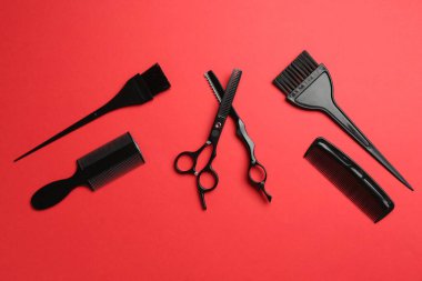 Kırmızı arka planda farklı kuaför aletleri, düz yatıyordu