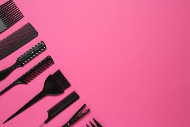 Pembe arka planda farklı kuaför aletleri, düz yatış. Metin için boşluk