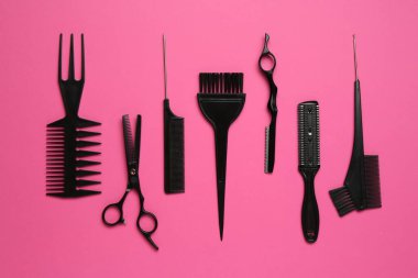 Pembe arka planda farklı kuaför aletleri, düz yatış